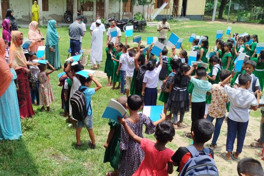 学習に欠かせないノートやペンを提供する様子