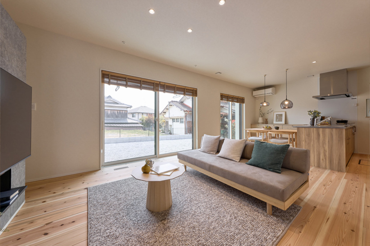 大きな窓から自然光が差し込む、木の温もりに包まれた開放的なLDK空間。