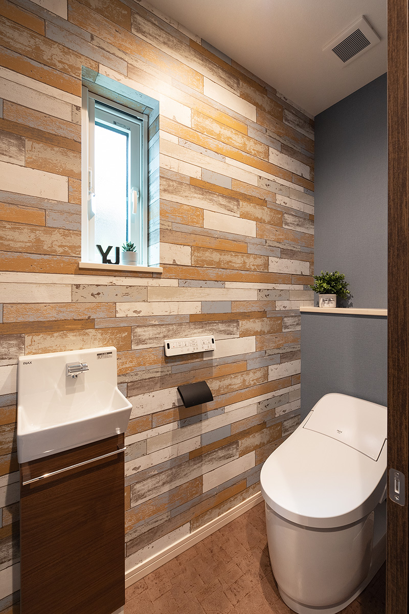 ［神戸市西区］ダブル断熱仕様のZEH（ゼロエネルギーハウス）ヤマト住建モデルハウスのレンガ調アクセントクロスのおしゃれなトイレ