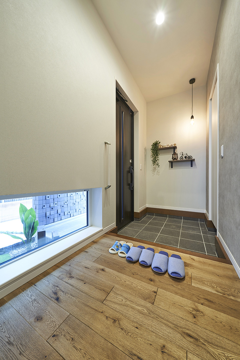 ［埼玉県所沢市］ダブル断熱仕様のZEH（ゼロエネルギーハウス）ヤマト住建モデルハウスの地窓から坪庭が見える玄関